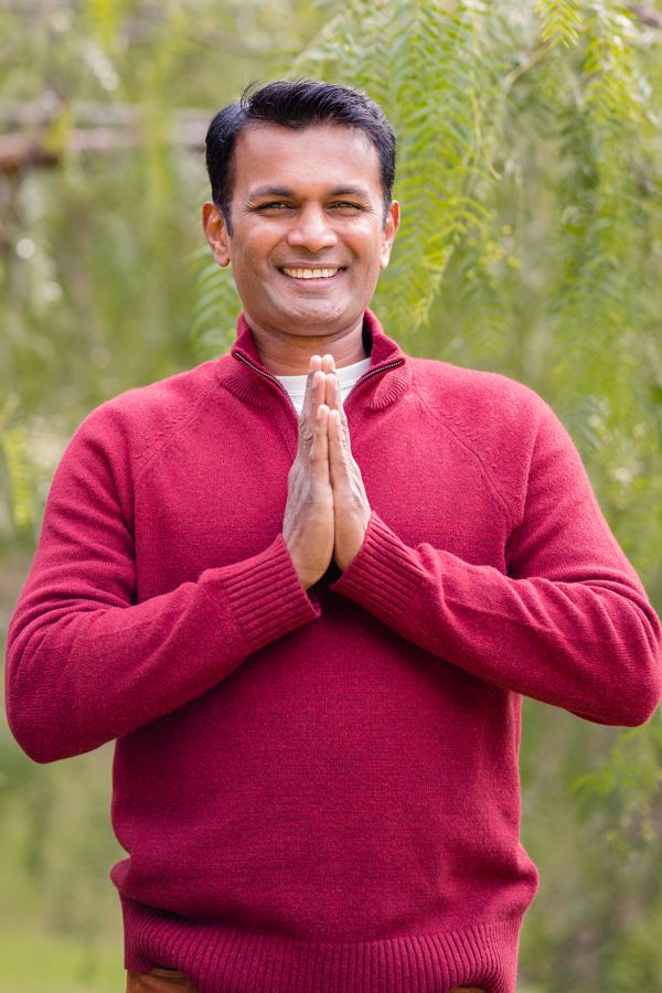 Jay with palms together in a namaste greeting