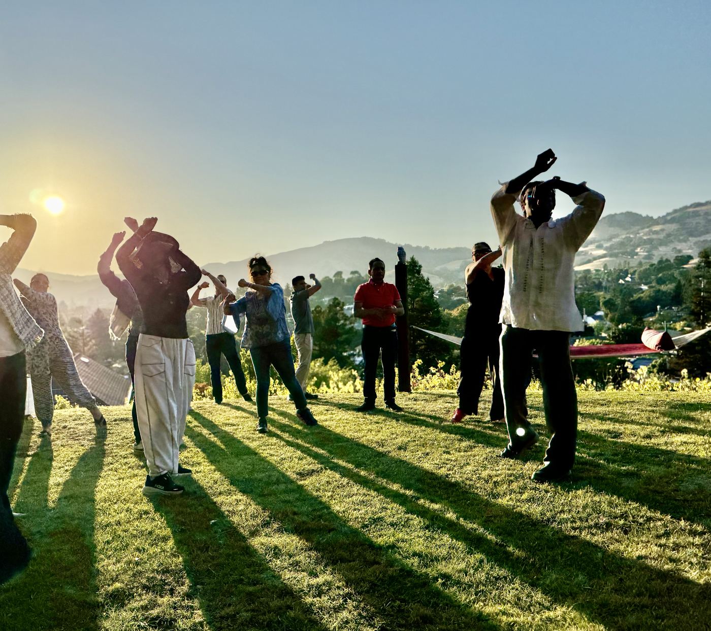 Guests moving together on a hilltop lawn at sunset in Marin